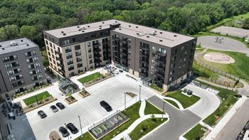 an aerial view of an apartment building and parking lot